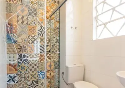 Banheiro da suíte confortável pousada próxima ao metrô Oscar Freire com azulejos artesanais