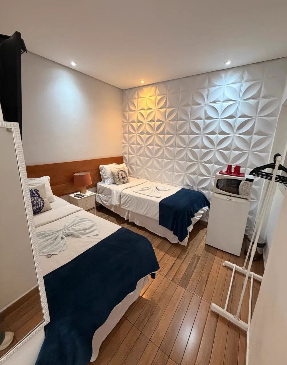 Quarto twin do hostel econômico em São Paulo com painel 3D e mini copa